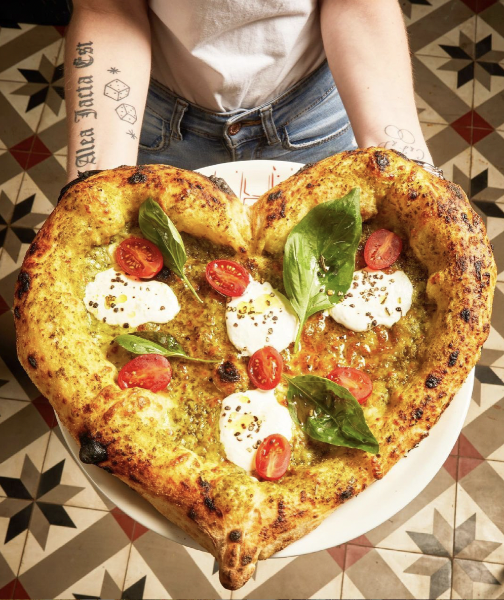 Pizza en forme de coeur présenté sur une assiette blanche