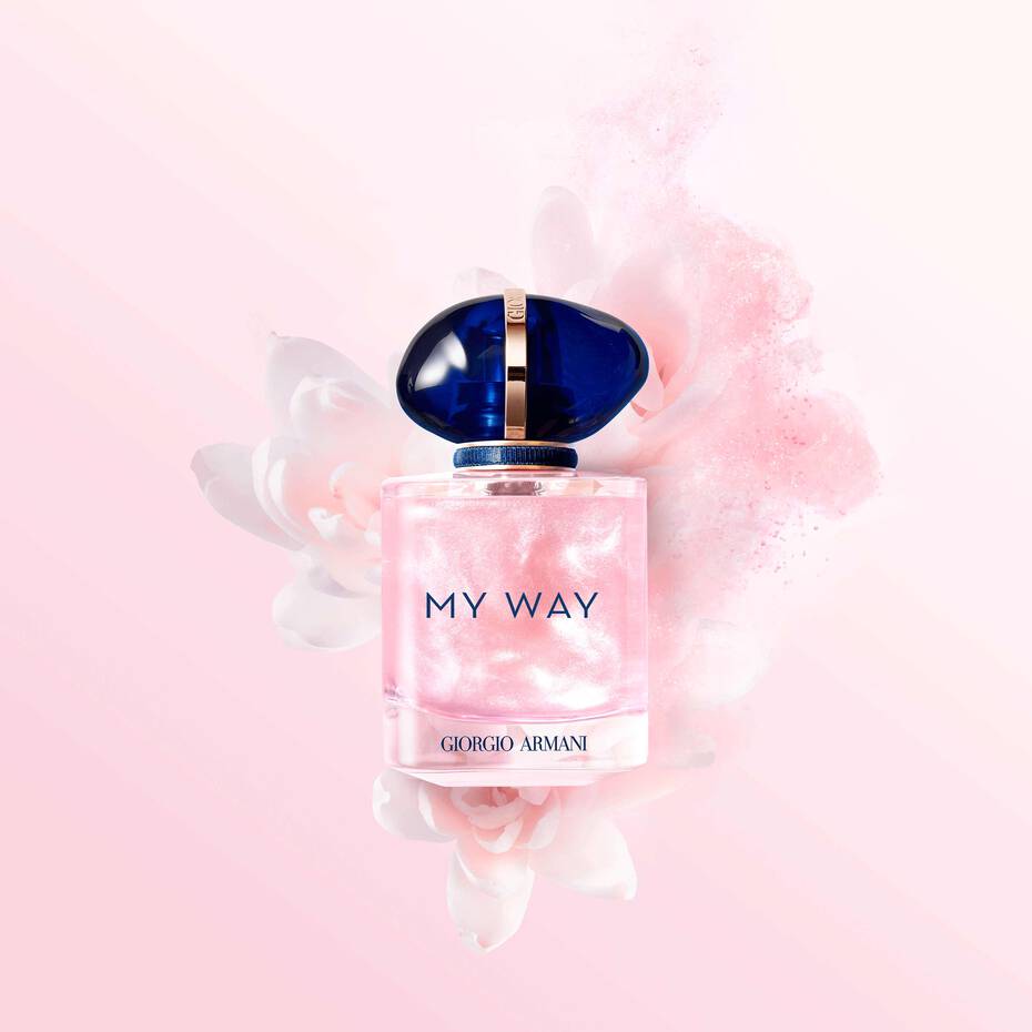 Eau de parfum My Way de Giorgio Armani édition Nacré sur un fond rose avec derrière des fleurs et de la poudre