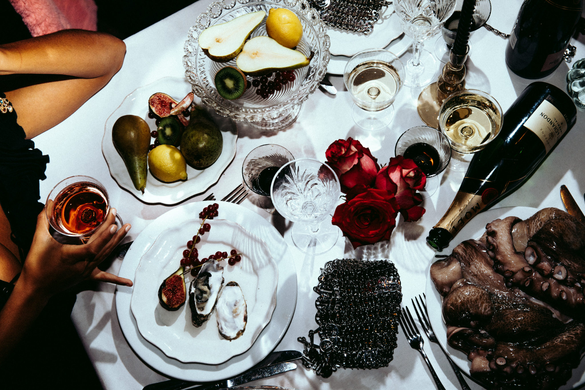 Assiettes dressées avec des fruits de mer et une bouteille de champagne renversée